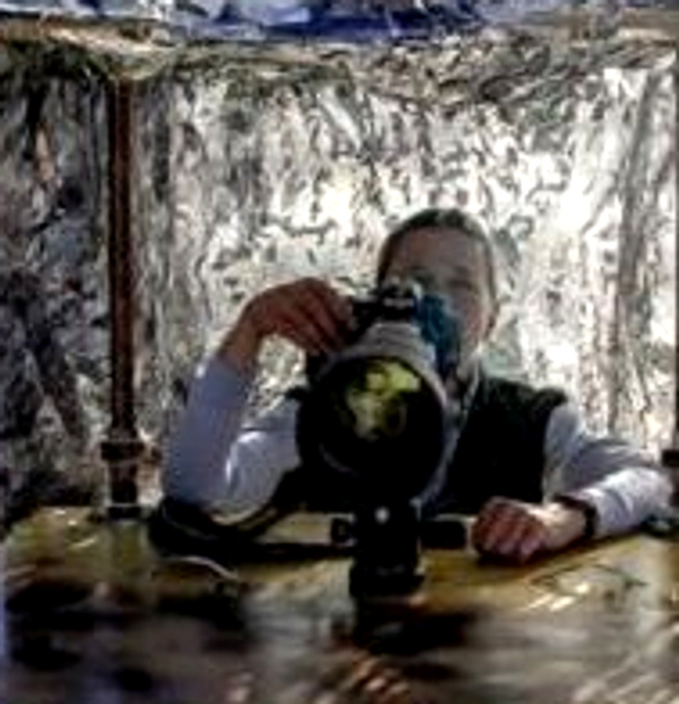 Lynn Starnes photographing from inside a camouflaged blind, behind a large telephoto lens